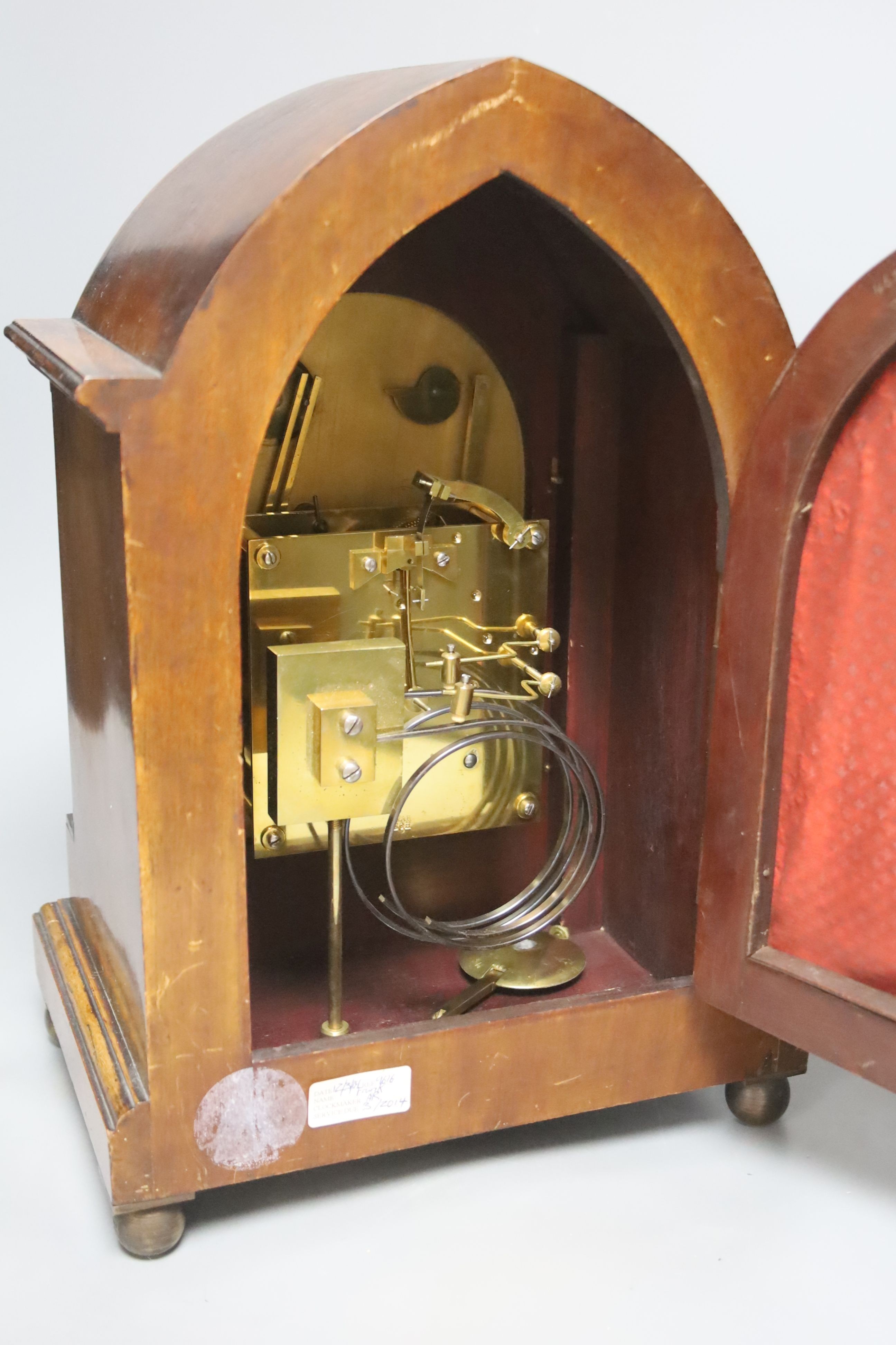 An inlaid mahogany lancet shaped chiming mantel clock with silvered dial, circa 1900. Pendulum and key. 38cm